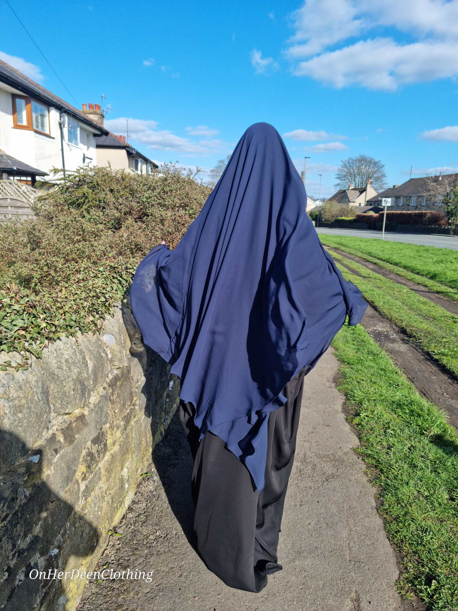 Woman wearing a chiffon 2 layer khimar in a navy colour from on her deen clothing