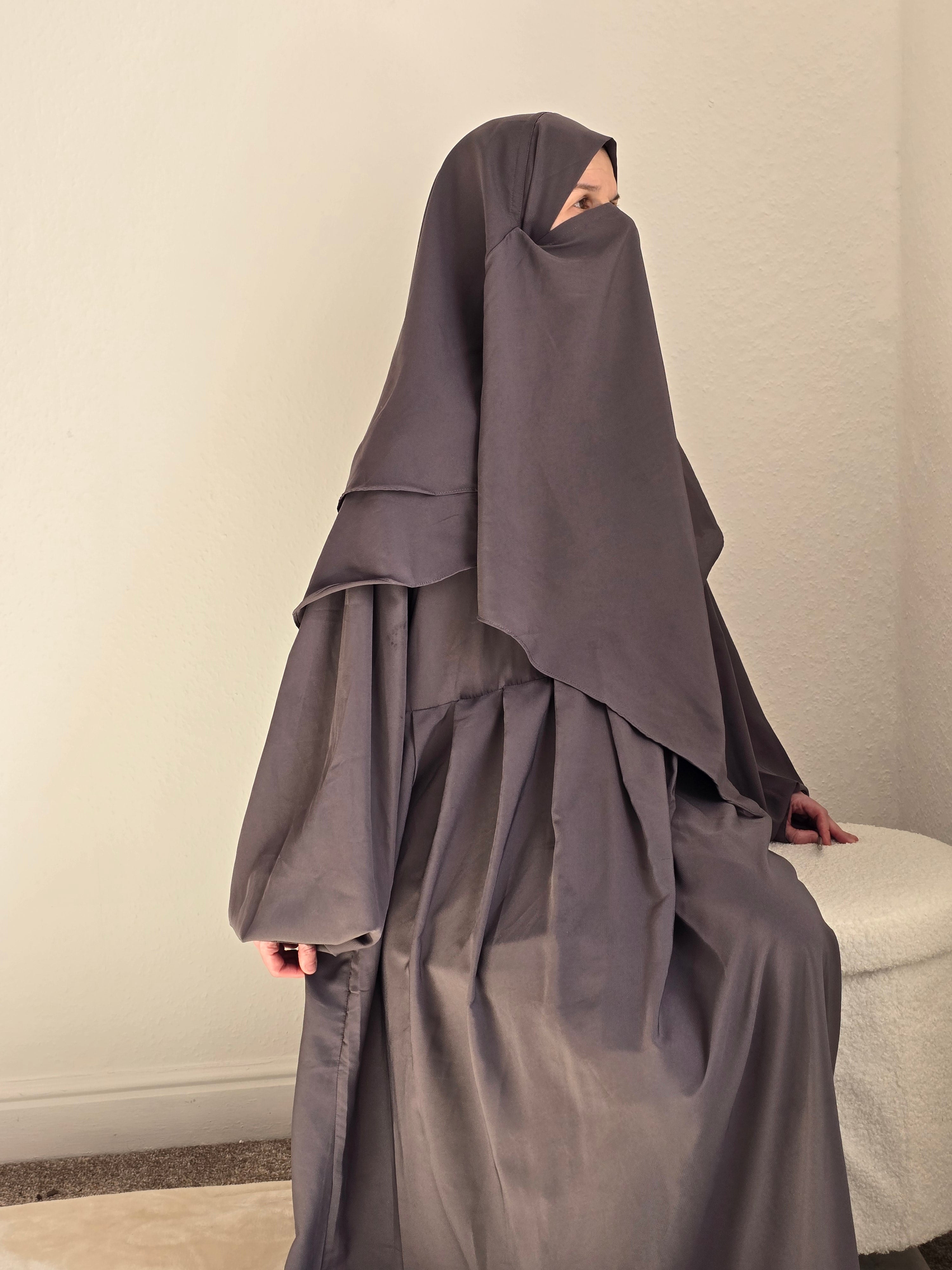 Women sat down in grey 2 piece abaya and khimar set