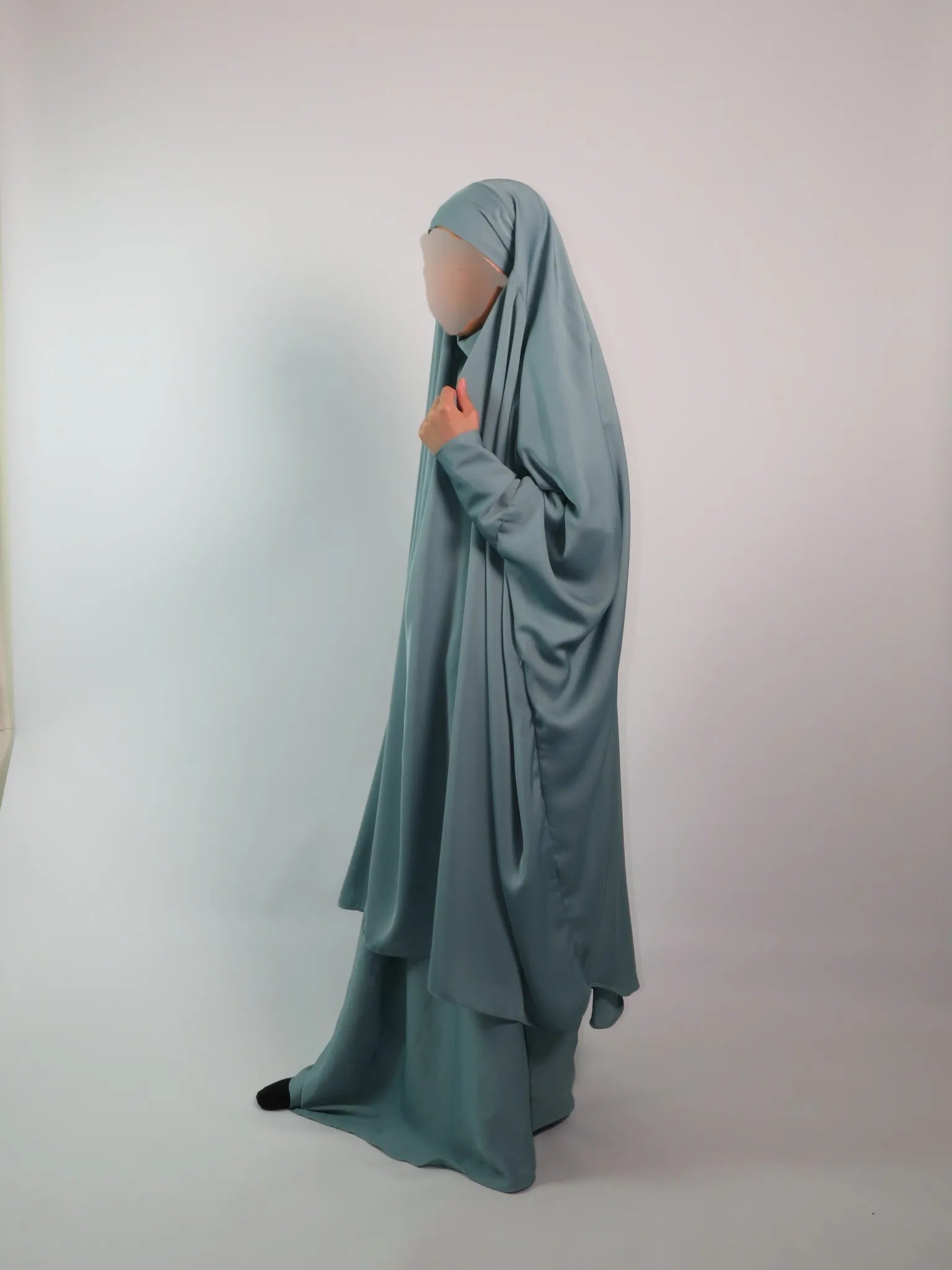 Women in turquoise blue jilbab with cargo pockets on a white background