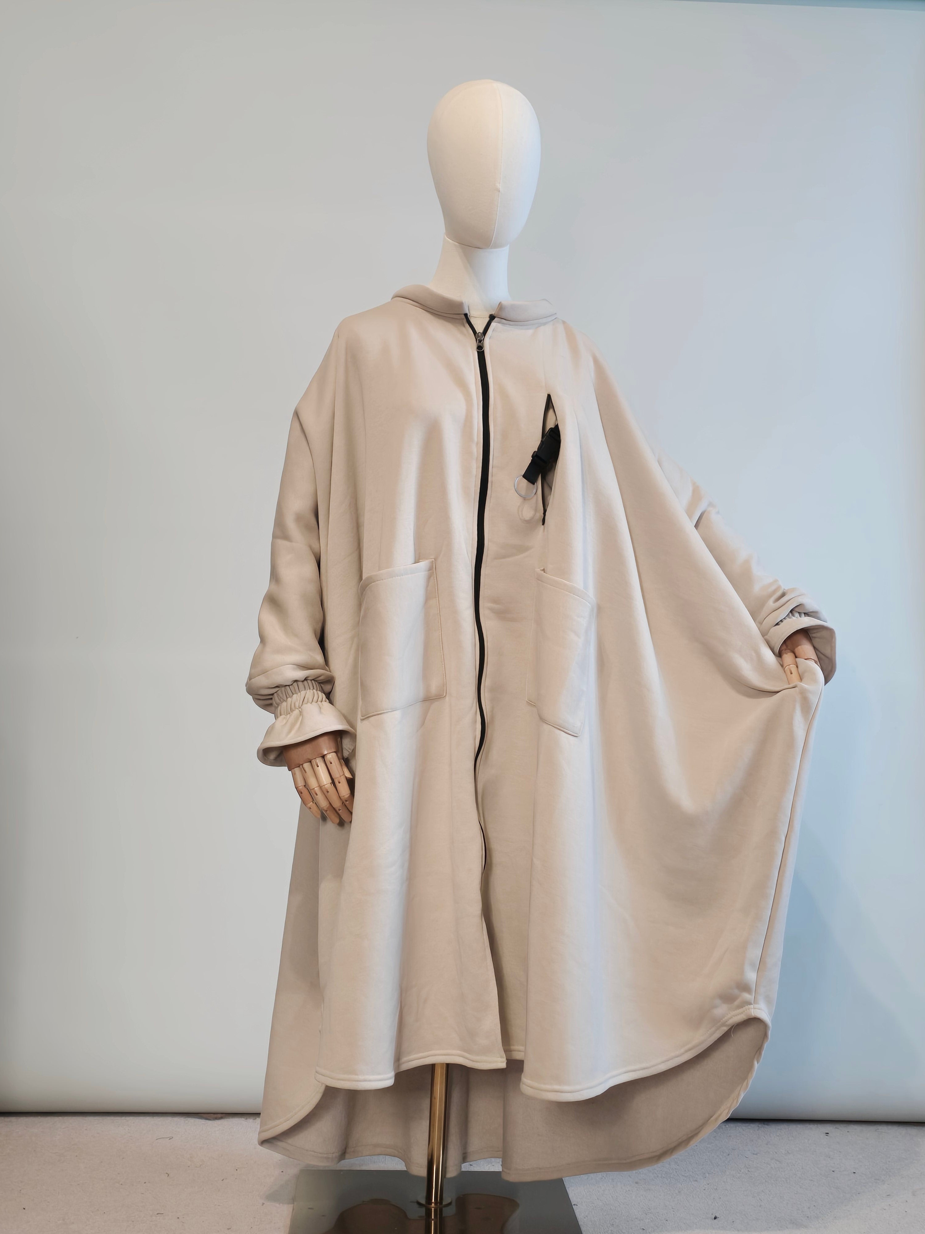 Musk white trench Abaya coat on a mannequin against a plain background
