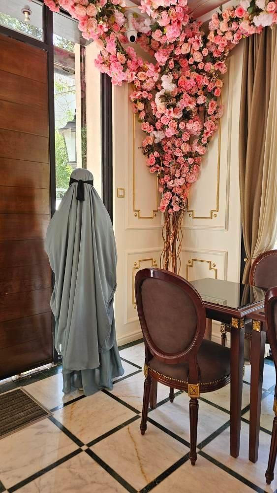 Women stood in restaurant wearing two piece pastel blue jilbab