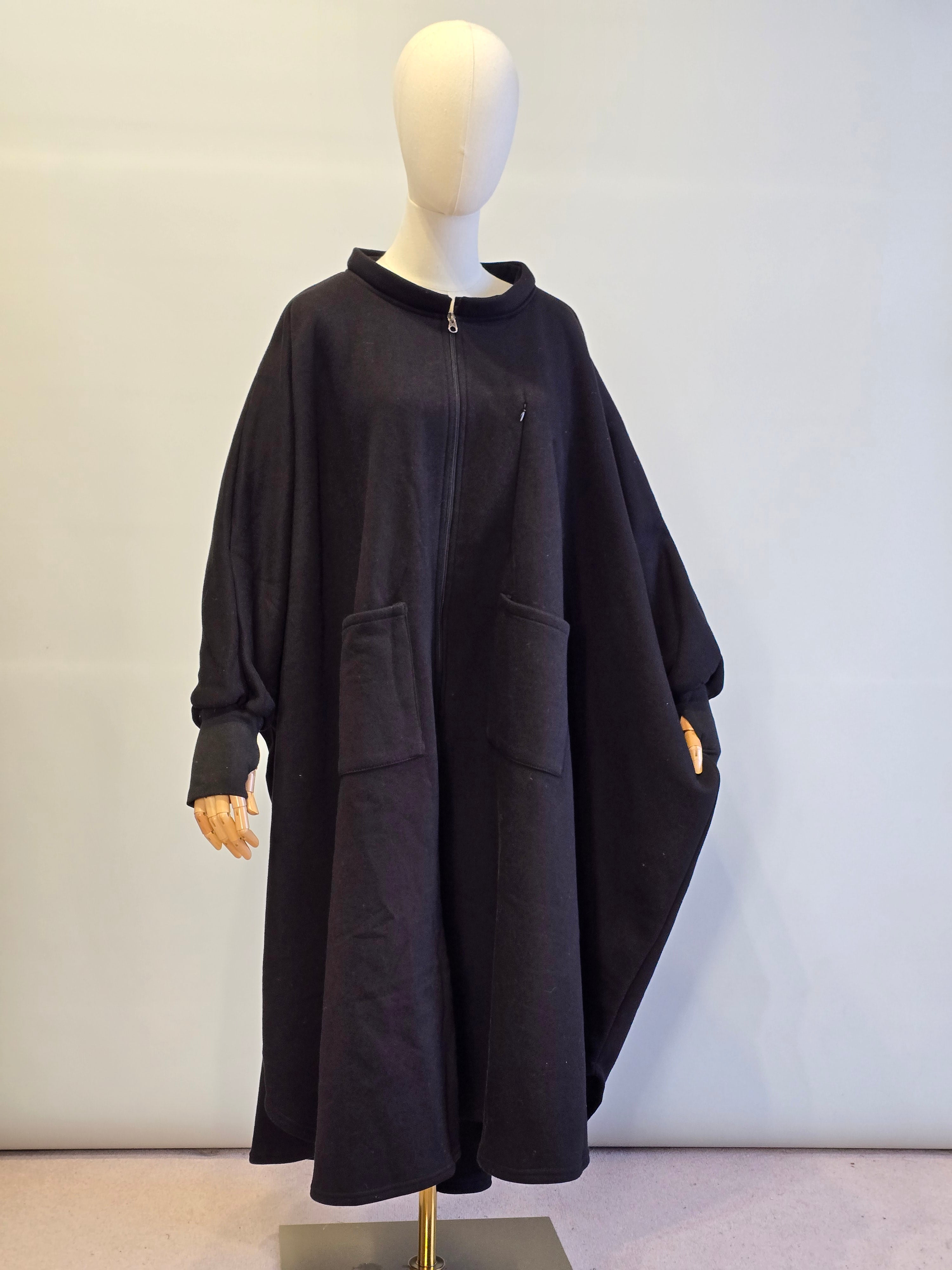 Black jacket on a mannequin against a plain background