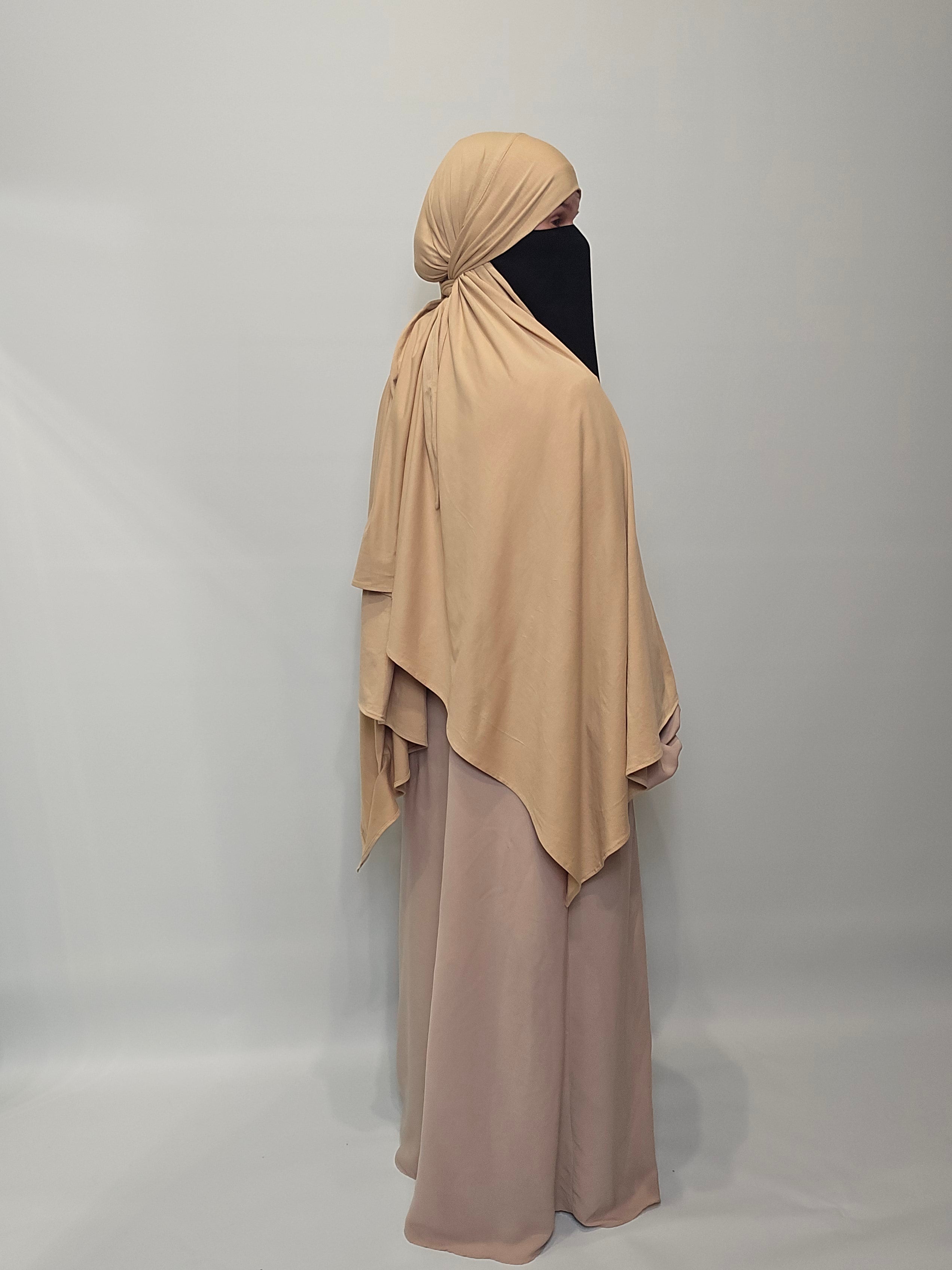 Beige abaya with matching hijab on a plain background