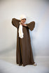girl wearing a brown double pocket abaya with a cream hijab on a white background 
