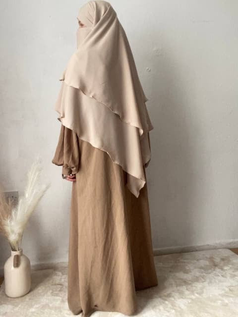 women stood in cream khimar and beige abaya indoors 