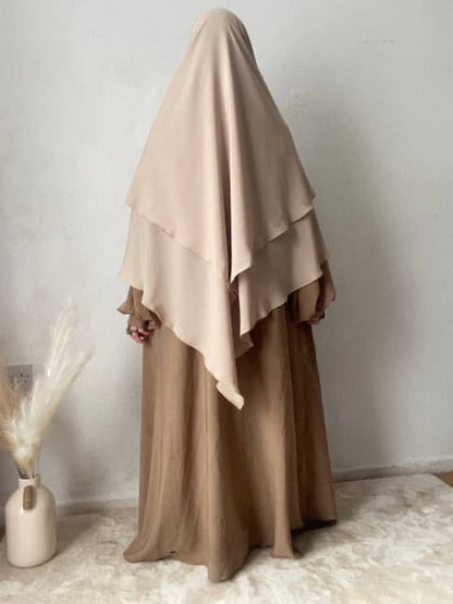 woman stood in a 2 layer cream khimar stood indoors 