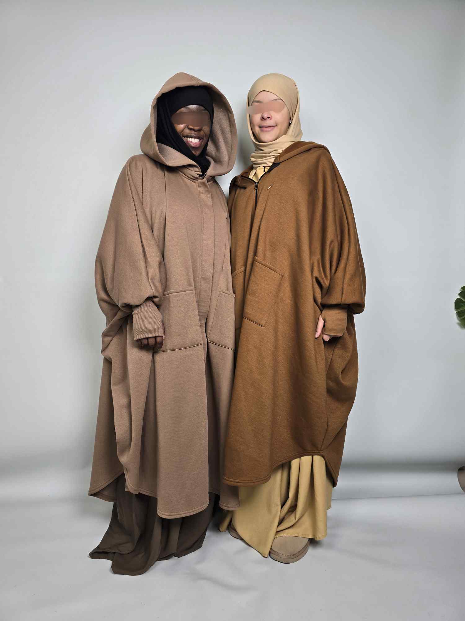 Two women in Al haya oversized poncho abaya fleece in mocha and taupe colours on a white background 