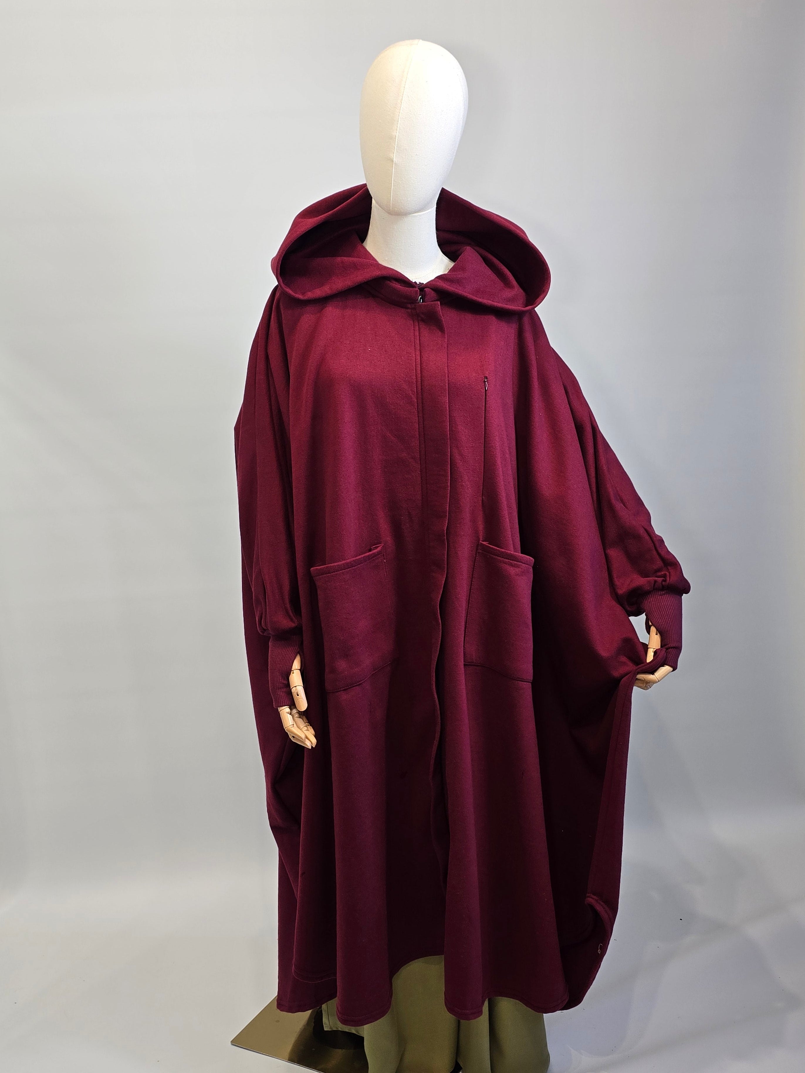 Maroon abaya fleece a mannequin against a white background
