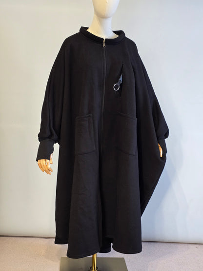 Black coat on a mannequin against a plain background