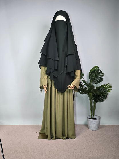 MANNEQUIN IN FOREST GREEN CHIFFON KHIMAR AND ABAYA DRESS ON A PLAN BACKGROUND