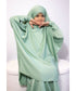 Girl what green jilab sat on chair on a white background 
