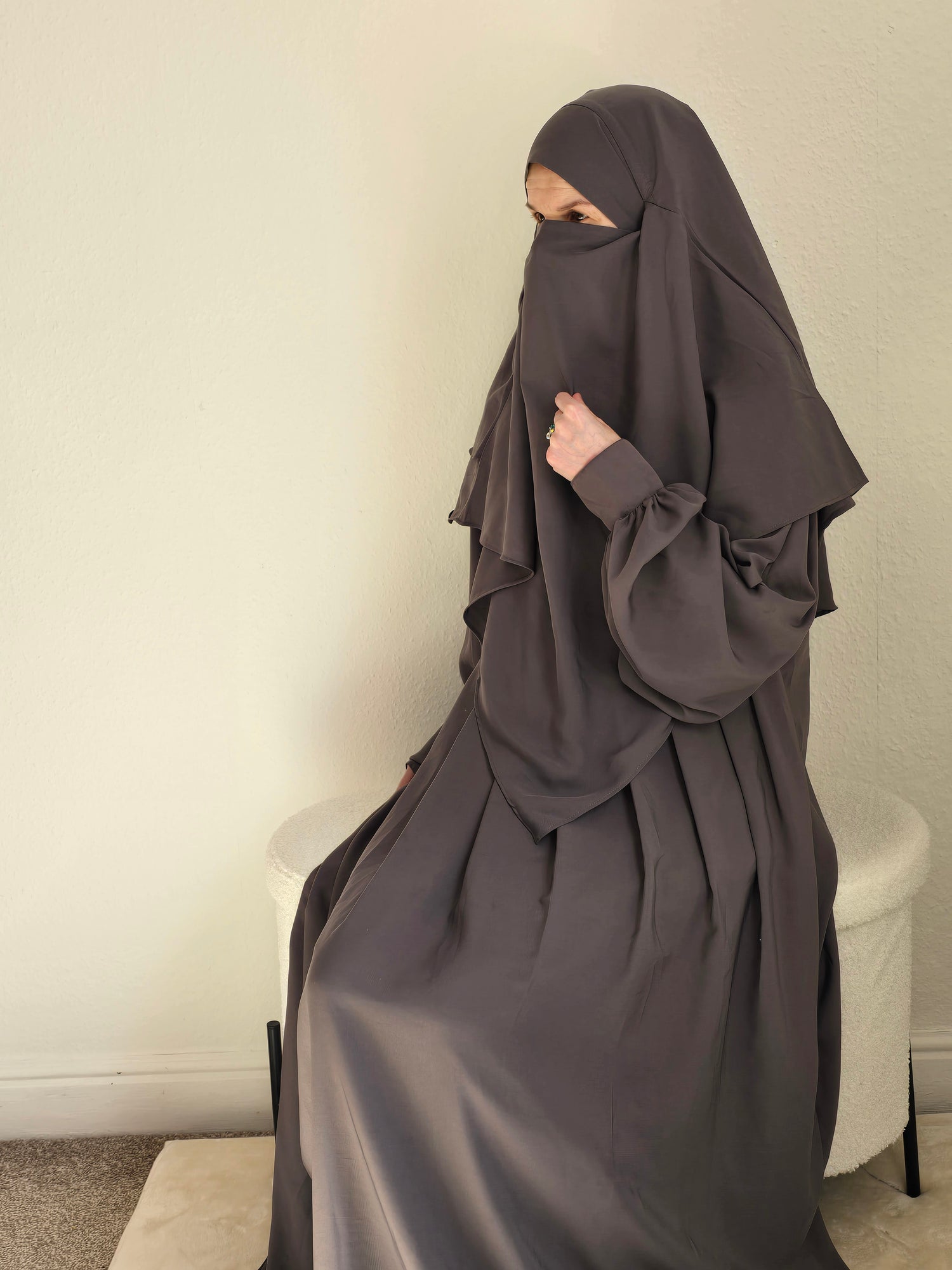 Women sit in a 2 piece abaya and khimar set 