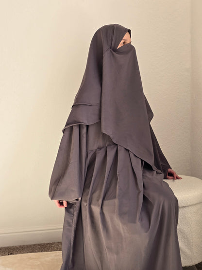 Women sat down in grey 2 piece abaya and khimar set 