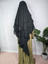 women in forest green 3 layer khimar pair with a sage green abaya on a white background with a plant