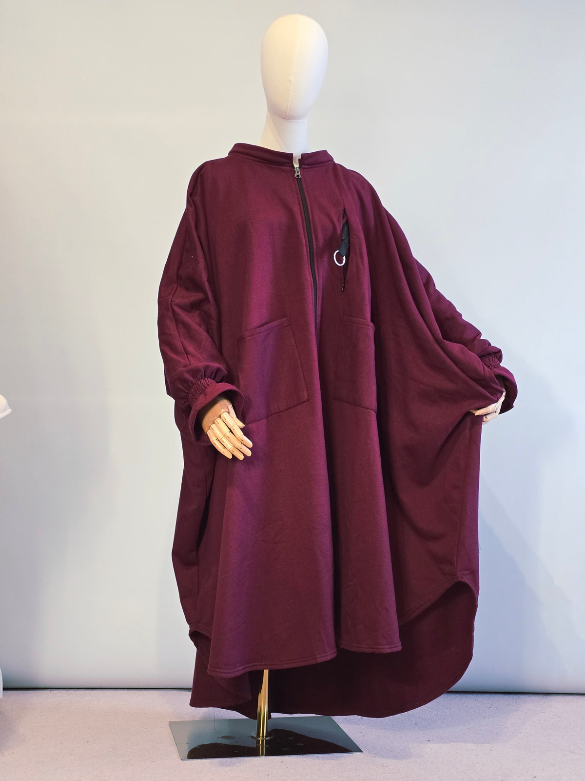 Maroon jacket on a mannequin against a light background