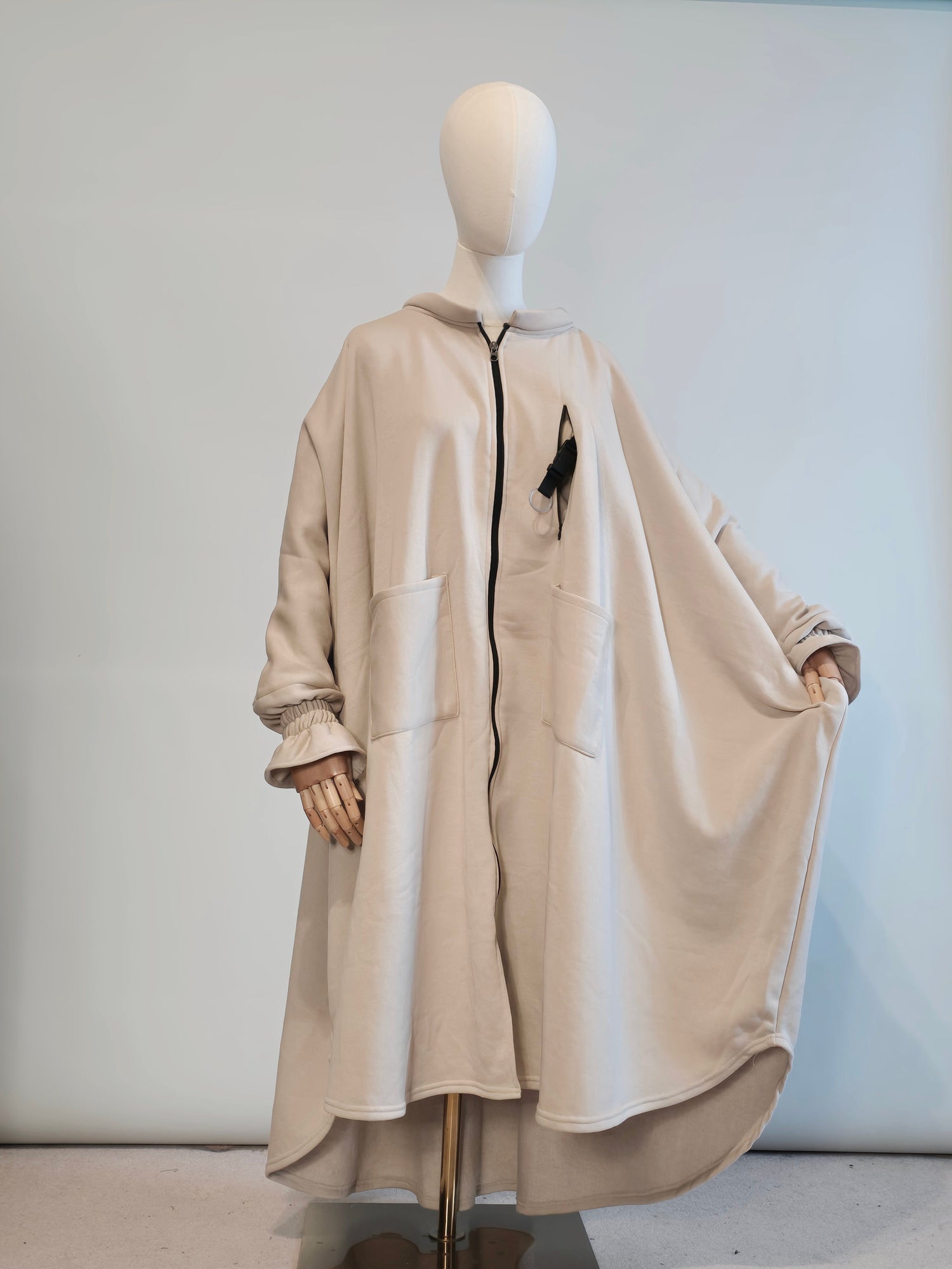 Musk white  trench  Abaya coat on a mannequin against a plain background