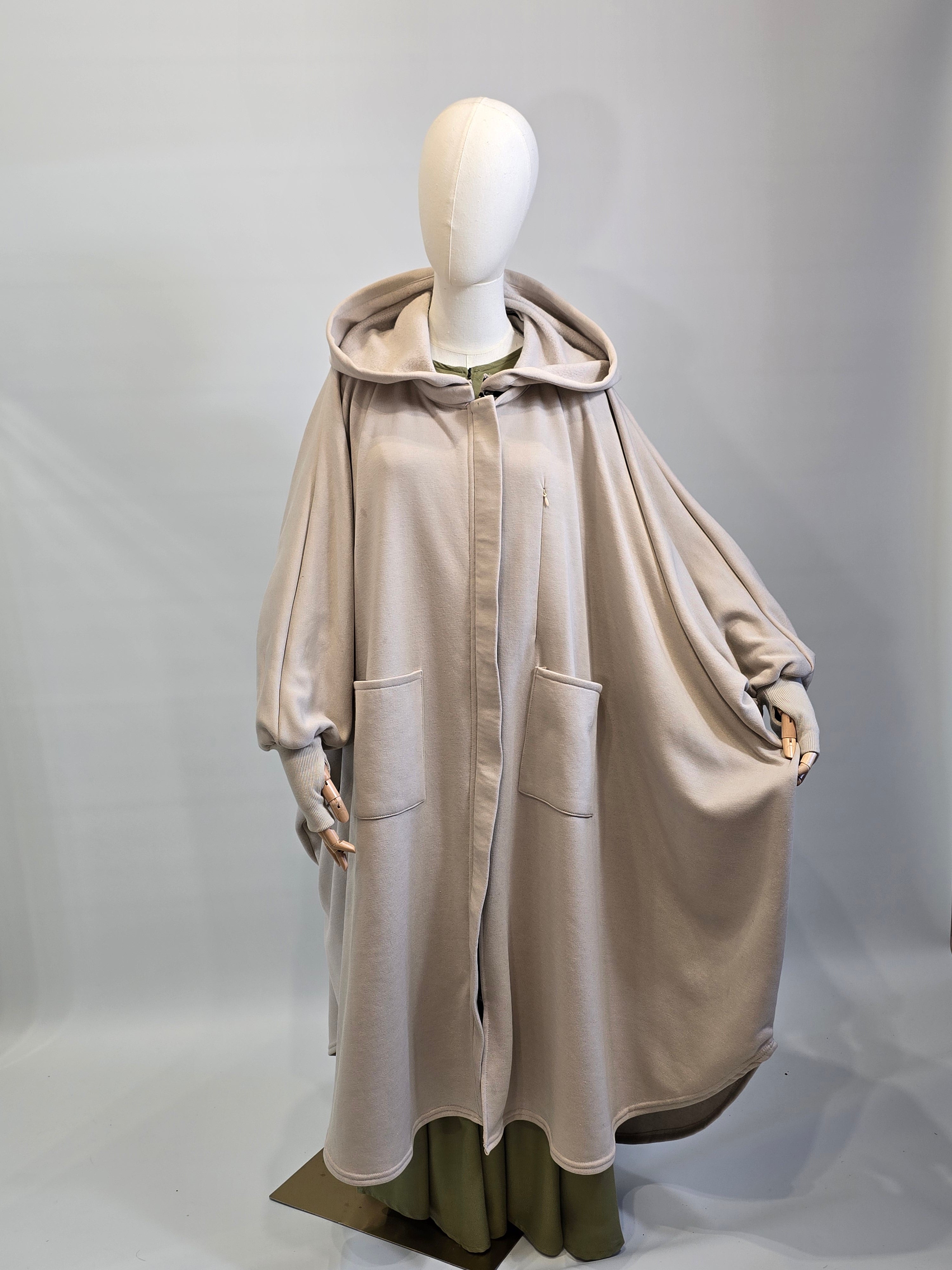 Mannequin wearing a beige trench coat on a plain background