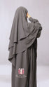A woman wearing a gray two-layered diamond khimar with niqab ties, designed for full coverage of the face and body.
