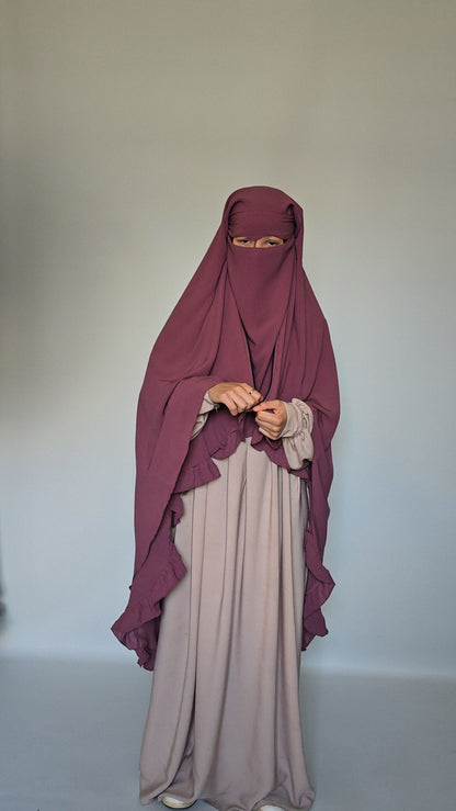 woman wearing 3 layer long modest niqab with widow peak style with a nose string on a white studio background 