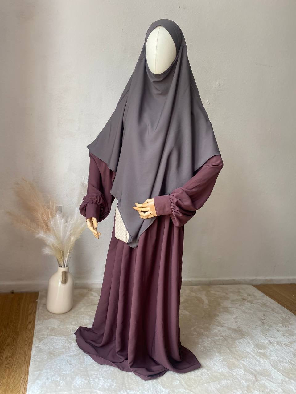 mannequin with a 2 layer khimar and dusky rose abaya stood on a white rug in a room 