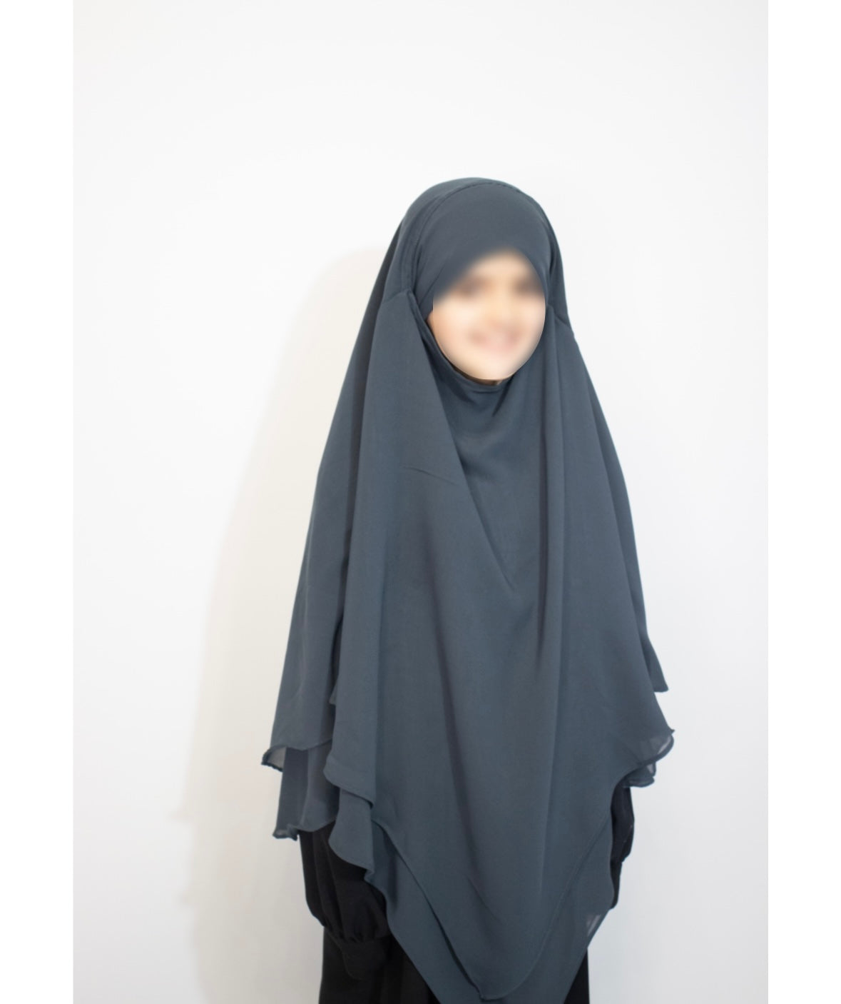 Person wearing a teal blue hijab against a white background