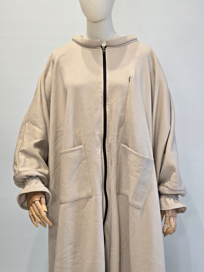 Mannequin wearing a musk white oversized abaya hoodie on a light gray background