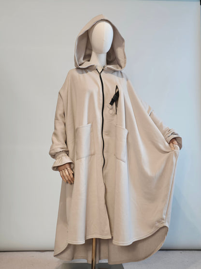 musk white hooded poncho abaya coat on a mannequin against a plain background